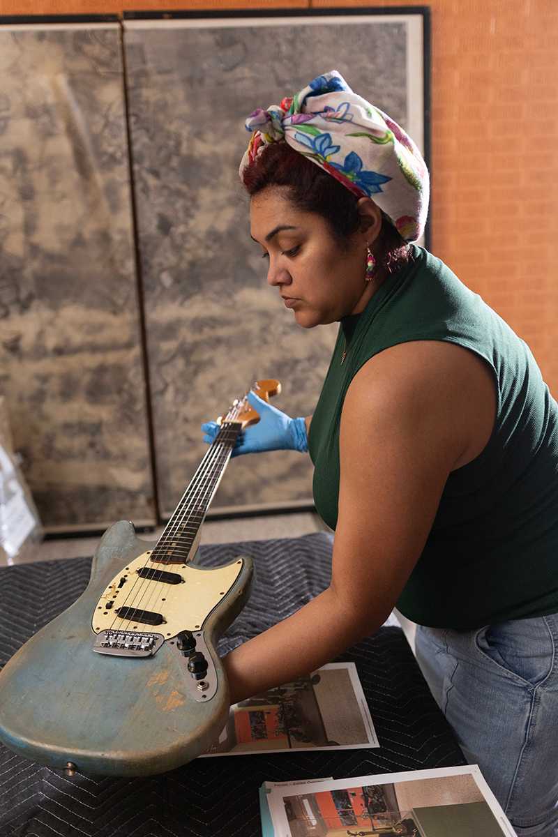 Veronique carefully placing a guitar on a table